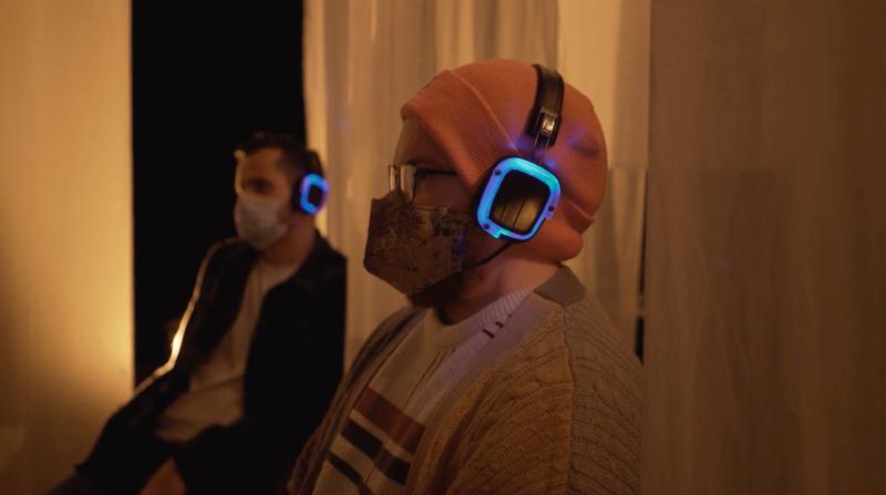 An audience member with wireless headphones on watching Seance