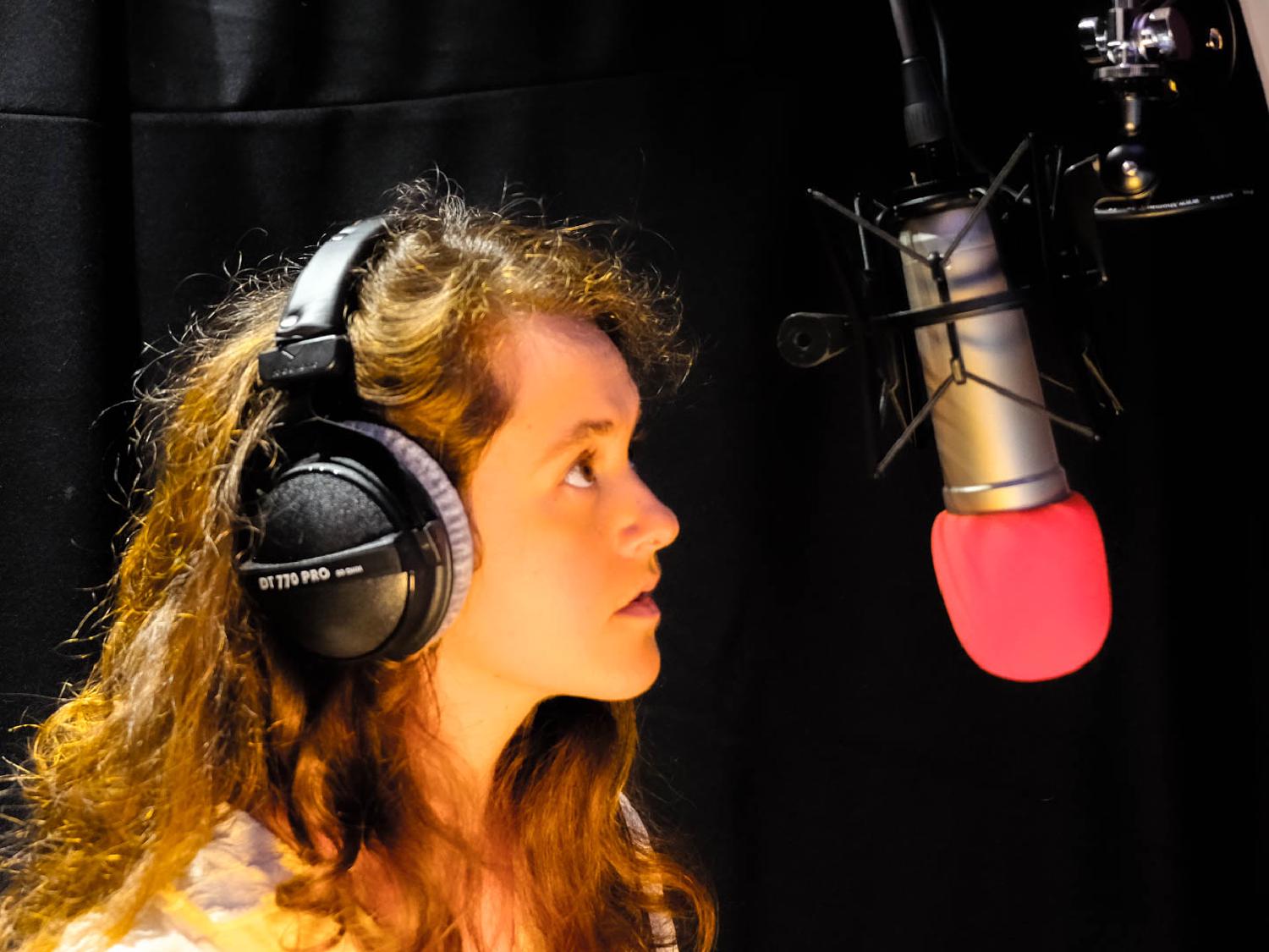 "Rae Emily George in a studio recording corporate voiceover"